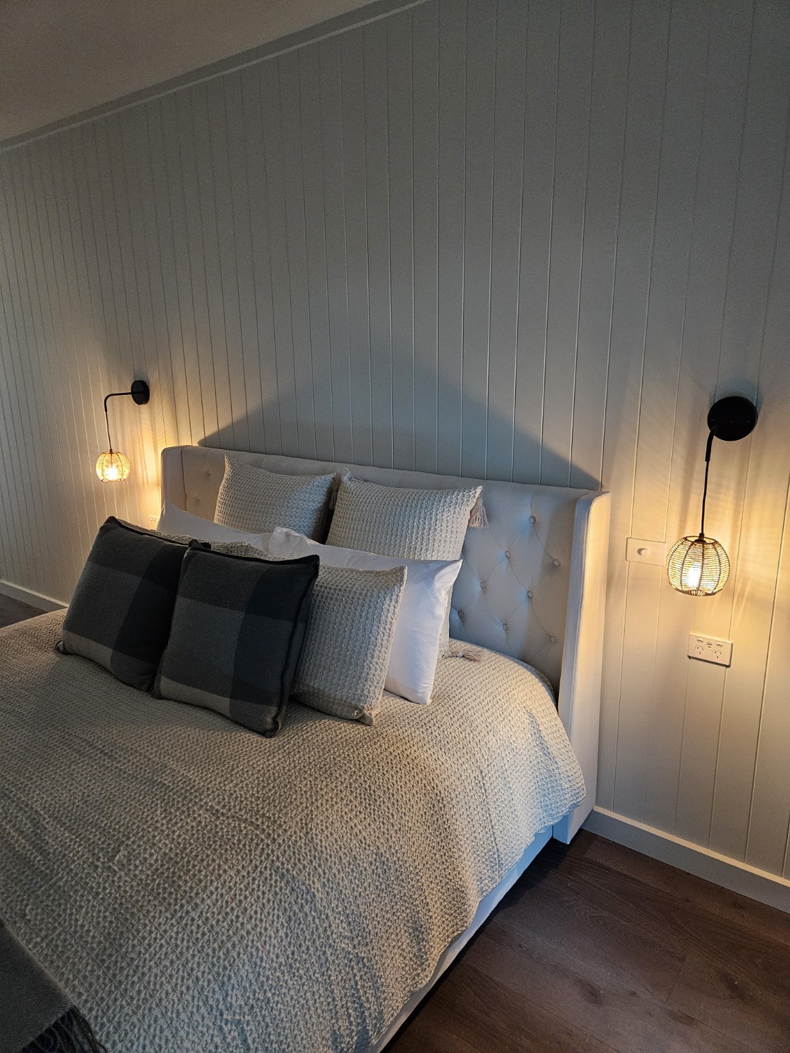 Warm bedside feature lights installed in a finished bedroom