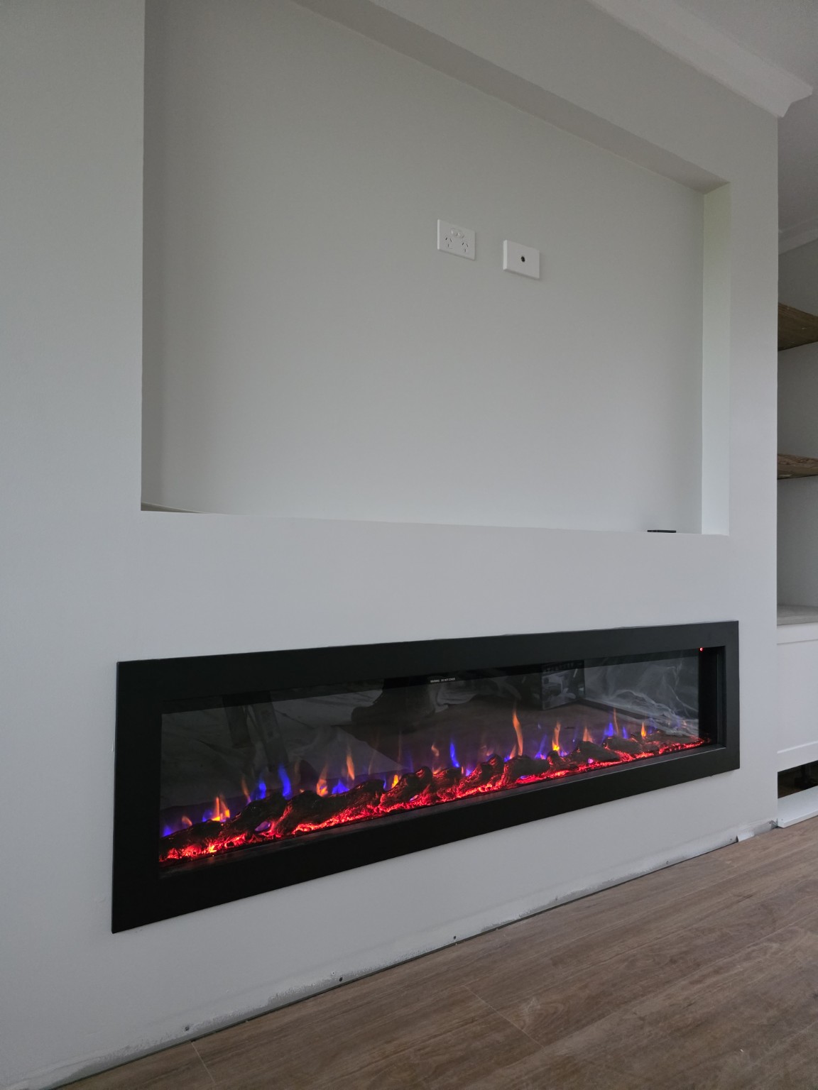 Long electric fireplace integrated into a residential feature wall