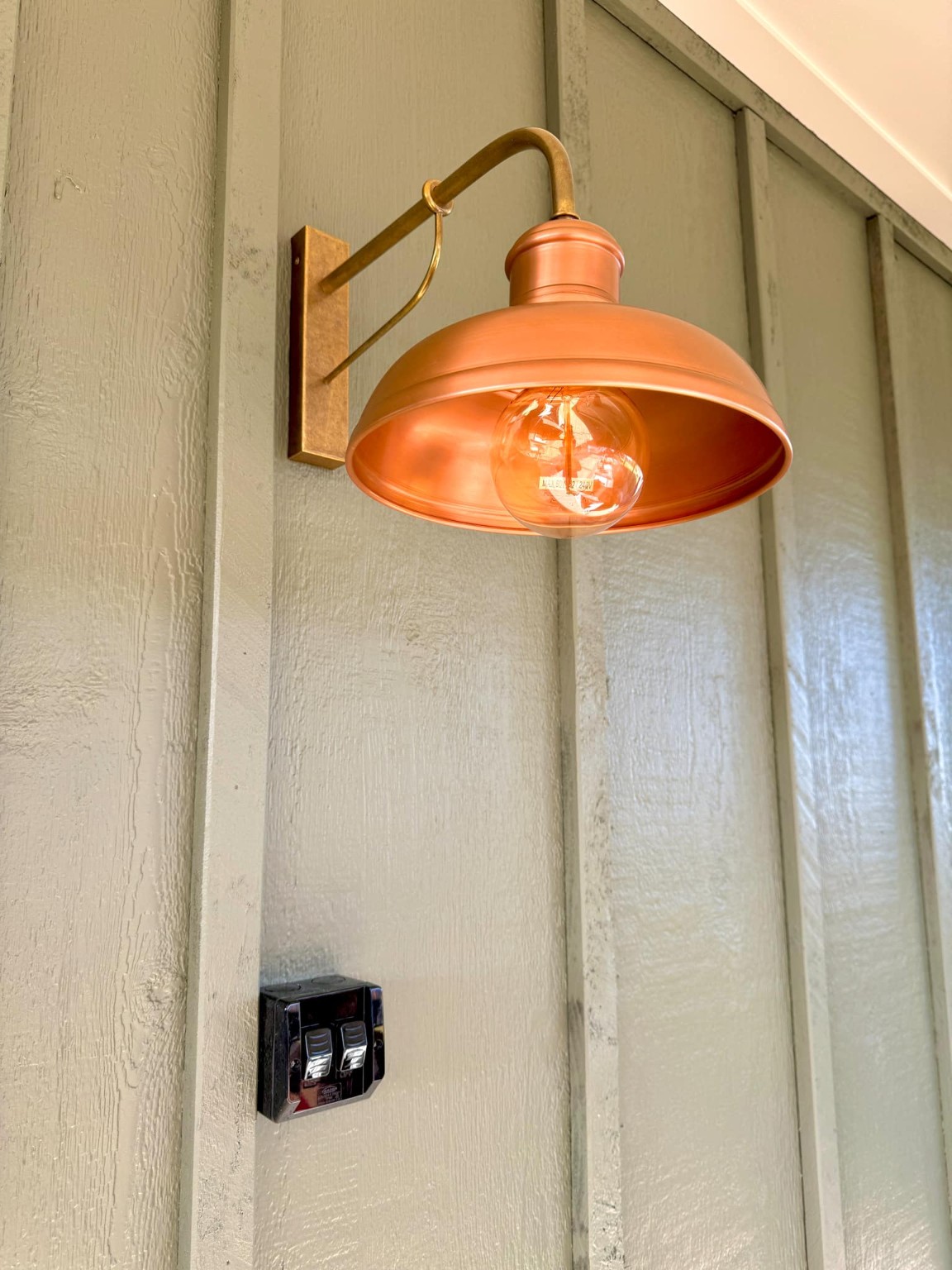 Copper exterior wall light with nearby weatherproof switches