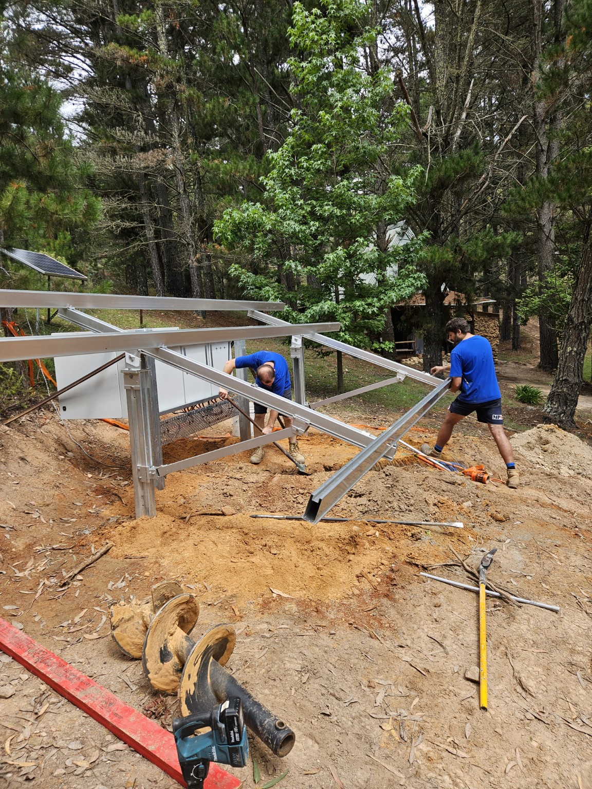 Swebs electricians constructing a ground-mount solar frame in a bush setting