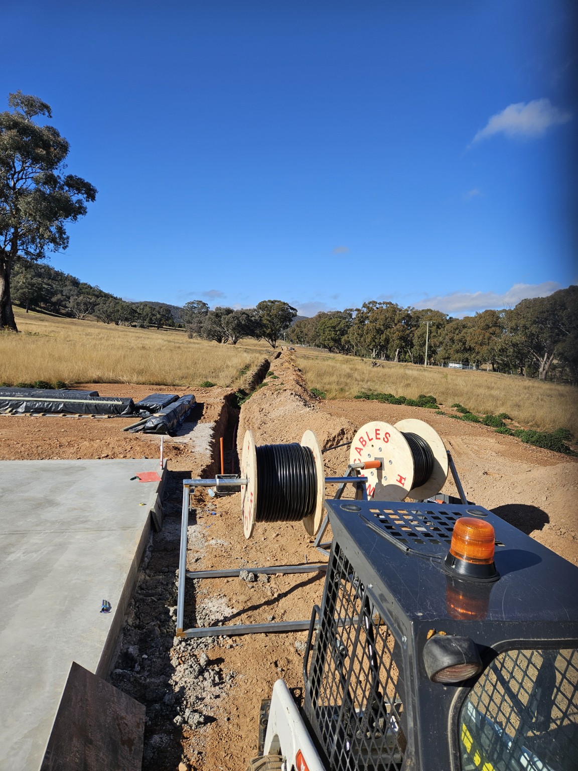 Long underground cable trench and cable drums at a regional build