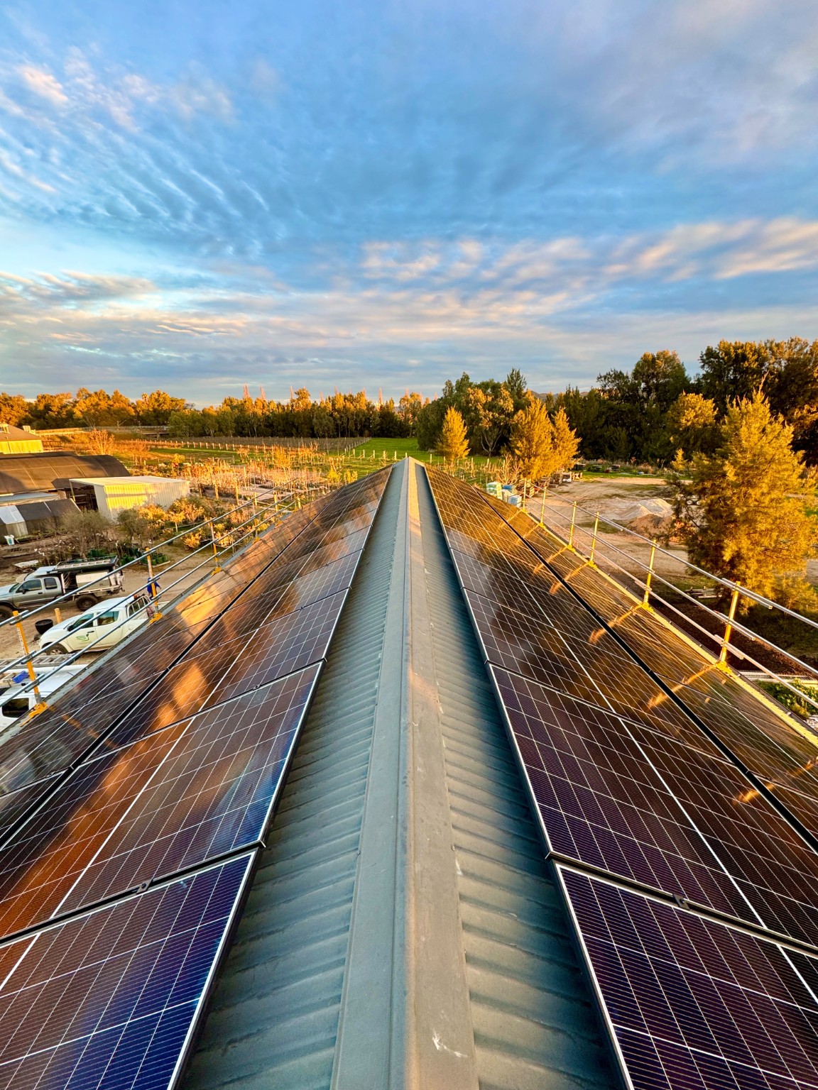 Large commercial solar installation across both sides of a regional building roof